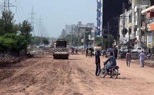 A survey team takes measurements as work continues on the extension and rehabilitation of the Islamabad Expressway service road near Faizabad interchange