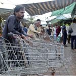 Labourers with handcarts wait for customers to carry their luggage at the weekly Sunday Bazaar in Aabpara, Federal Capital
