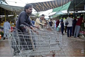 Labourers with handcarts wait for customers to carry their luggage at the weekly Sunday Bazaar in Aabpara, Federal Capital