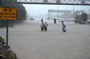 Vehicles passing through rain water accumulated on IJP Road after heavy rainfall in the Federal Capital