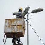 A TMA worker repairs a streetlight during routine maintenance work in the city