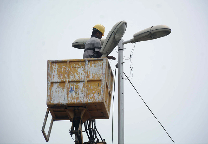 A TMA worker repairs a streetlight during routine maintenance work in the city
