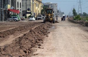 A survey team takes measurements as work continues on the extension and rehabilitation of the Islamabad Expressway service road near Faizabad interchange