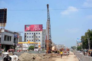 Labourers are busy construction work on Jaranwala Road with the help of heavy machineries during development work in metro project.