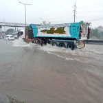 Vehicles passing through rain water accumulated on IJP Road after heavy rainfall in the Federal Capital