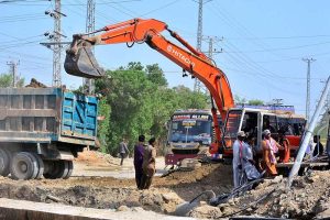 Labourers are busy with construction work on the sewerage nala at Badin Bus Stop Road during development work in the city.