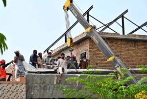A daily-wage labourer was killed when a concrete shade collapsed on him at an under-construction house in Media Town. Rescue teams retrieve the body from the debris.