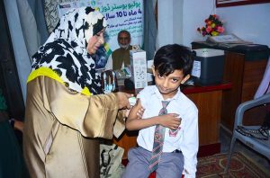 A lady health worker administers an anti-polio booster dose to a child during an anti-polio vaccination campaign at Laiba Montessori & high School.