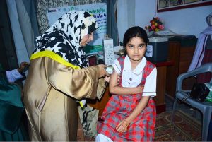 A lady health worker administers an anti-polio booster dose to a child during an anti-polio vaccination campaign at Laiba Montessori & high School.