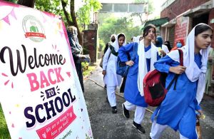 Students arrive at school on the first day after summer vacation in the Provincial Capital.