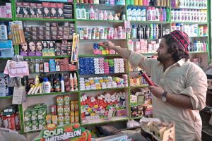 A shopkeeper arranging and displaying different items at his shop in Ghouri Town to attract the customers