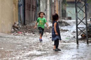 Children enjoying playing in the rain during the monsoon downpour; this spell of rain has broken the intense heatwave.