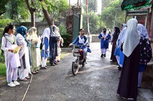 Students arrive at school on the first day after summer vacation in the Provincial Capital.