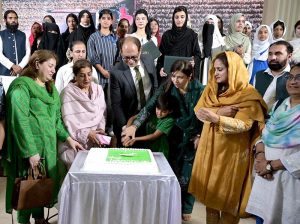 Federal Secretary Information and Broadcasting, Ashfaq Ahmad Khalil, cuts a cake to mark the 14th August Independence Day celebrations, during the painting exhibition organized by the Directorate of Electronic Media and Publications (DEMP), at the Information Services Academy.