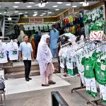 People are busy selecting and purchasing children's clothes containing Pakistani flags outside a shop at Bohar Bazaar in connection with Independence Day celebrations