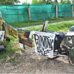 A painter is busy at work, creating a painting to sell along the roadside in the Federal Capital