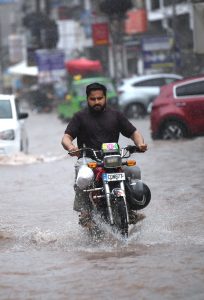Children enjoying playing in the rain during the monsoon downpour; this spell of rain has broken the intense heatwave.