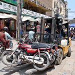Traffic police officials removed wrongly parked motorcycles with a fork lifter at Raja Bazaar