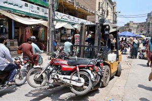 Traffic police officials removed wrongly parked motorcycles with a fork lifter at Raja Bazaar