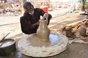 A craftsman busy in preparing clay-made stuff at his work place in Kumhar para