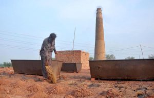 A worker put the fuel into the firing chambers of a traditional brick kiln to maintain the intense heat required for baking raw bricks on the outskirts of the city.