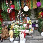 Vendors wait for customers at a shop displaying a colorful collection of artificial flowers and decorative plants at H-9 weekly bazaar, as demand for home décor items continues to grow in the Federal Capital