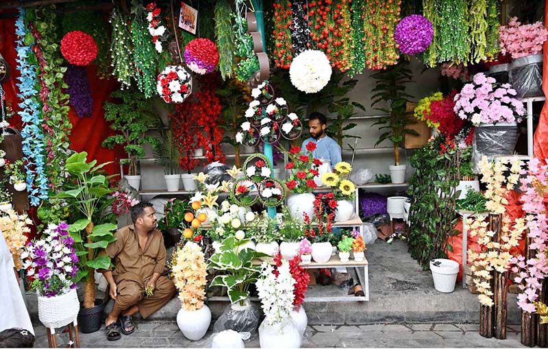 Vendors wait for customers at a shop displaying a colorful collection of artificial flowers and decorative plants at H-9 weekly bazaar, as demand for home décor items continues to grow in the Federal Capital