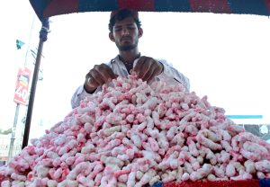 A roadside vendor displays traditional sweet treats, known as Tangri, to attract customers and earn a livelihood for his family