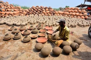 A craftsman busy in preparing clay-made stuff at his work place in Kumhar para