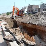 Workers fill the dug-up area with heavy machinery after laying the sewerage pipeline during ongoing development work in Mumtazabad