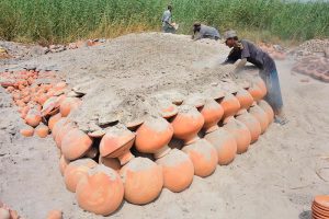 A craftsman busy in preparing clay-made stuff at his work place in Kumhar para