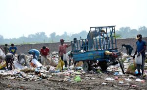 Scrap collectors from the Gypsy community search through a heap of garbage for recyclable and reusable items to earn a livelihood.