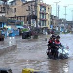 Vehicles drive through flooded streets after heavy rainfall in the Rahimabad area