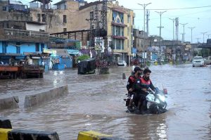 Vehicles drive through flooded streets after heavy rainfall in the Rahimabad area