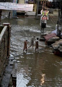 Residents wade through knee-deep floodwater as heavy rains submerge streets near imam bara chowk.