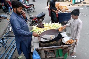 Women buy roasted beans, lentils and traditional food items from vendor at Delhi Gate