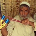 A vendor checks wooden slingshots at his workplace in the Dabgari area