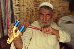 A vendor checks wooden slingshots at his workplace in the Dabgari area