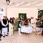 High Commissioner Rabia Shafiq, joined by members of the Pakistani community, cuts a cake to mark the 79th Independence Day of Pakistan during a flag-hoisting ceremony at Pakistan House