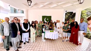 High Commissioner Rabia Shafiq, joined by members of the Pakistani community, cuts a cake to mark the 79th Independence Day of Pakistan during a flag-hoisting ceremony at Pakistan House