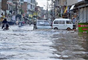 Vehicles drive through flooded streets after heavy rainfall in the Rahimabad area