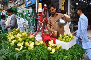 A vendor prepares and serves fresh sweet lime juice to a customer seeking relief from the extreme heat at Qissa Khawani Bazaar.