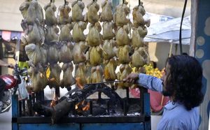A street food specialist prepares traditional, mouth-watering 'Chicken Sajji' at his stall in Bani Market; the appetizing aroma of this popular dish is drawing customers in across the twin cities.