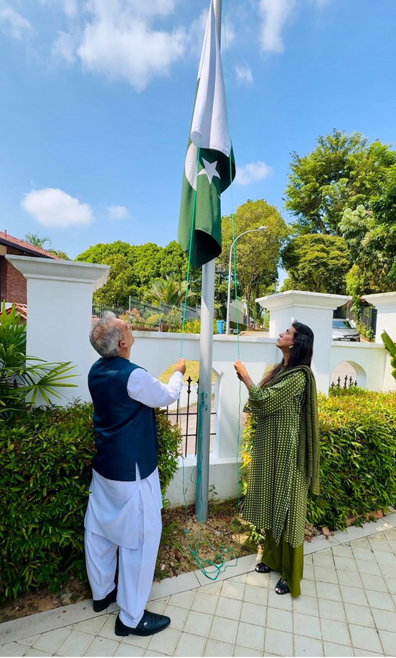 High Commissioner Rabia Shafiq raises the national flag to the tune of the national anthem during a flag-hoisting ceremony at Pakistan House, to mark the 79th Independence Day of Pakistan