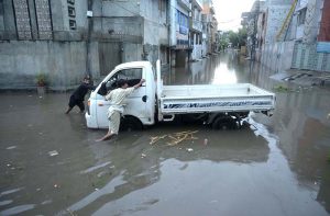 Vehicles drive through flooded streets after heavy rainfall in the Rahimabad area