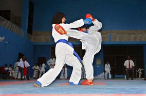 Young female karate players compete during the 1st Junior South Punjab Azadi Karate Championship at the Sports Gymnasium.