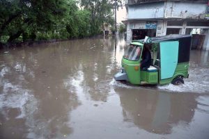 Vehicles drive through flooded streets after heavy rainfall in the Rahimabad area