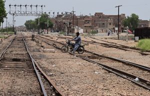 A motorcyclist crosses the railway track near the railway station, risking a possible accident