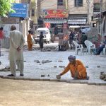 Labourers are busy fixing cemented tiles on road at GOR Colony
