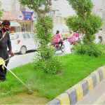 PHA workers trim grass along a road median to maintain the greenery and beautification of the city